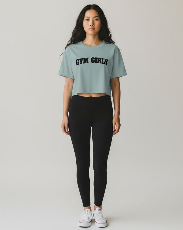 GYM PANTHERS light blue cotton blend crop top with black 'Gym Girly' text graphic. Relaxed fit, short sleeves.