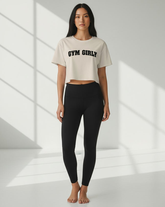GYM PANTHERS cream cotton blend crop top with black "Gym Girly" text, short sleeves, and relaxed fit.
