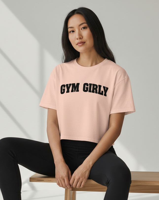 GYM PANTHERS light pink cotton crop top with black "Gym Girly" text. Relaxed fit, short sleeves, crew neck.